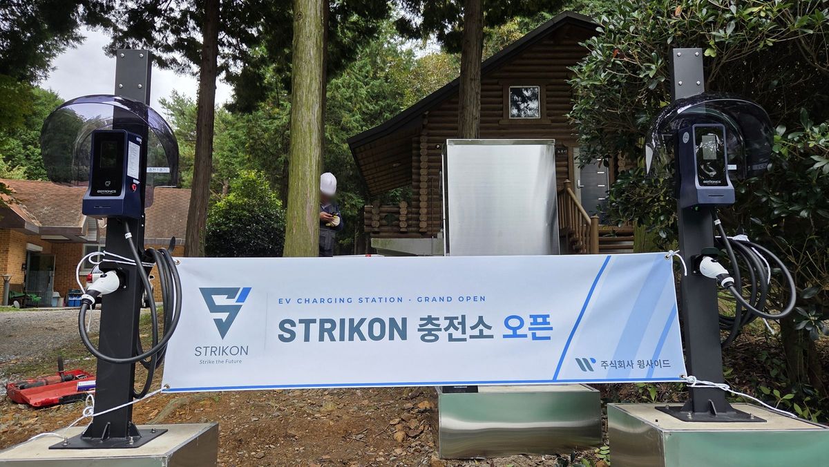 남해 편백 자연휴양림 숲속에 설치된 STRIKON 완속 충전기 2기와 개소 현수막